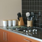 Cooking utensils contained in objects on kitchen counter